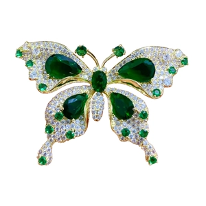 Broche papillon luxueuse avec pierres vert émeraude et cristaux pavés sur base dorée