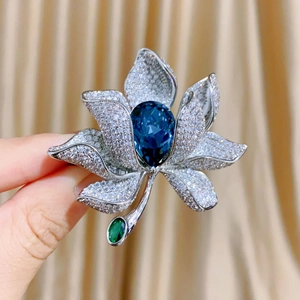 Luxuriöse Blumenbrosche mit blauem Kristall in Birnenform und funkelnden Blüten
