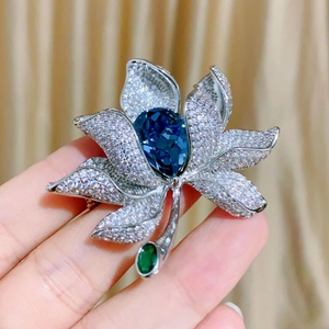 Detailansicht der Lotus-Brosche mit großem blauem Kristall und funkelnden weißen Zirkonia