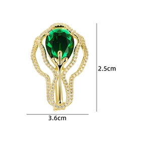 Détail de la broche goutte vert émeraude avec filigrane doré et pierres de zircon