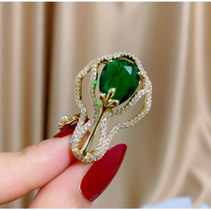 Exquise broche vintage émeraude avec cadre fleuri doré et accents de zircons étincelants