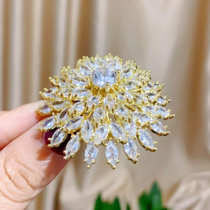 Macro view of multi-layered cubic zirconia sunflower brooch with brilliant marquise cut crystals