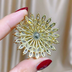 Close-up of golden sunflower brooch with marquise zircons and pin clasp detail