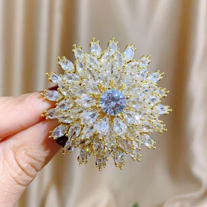 Macro shot of gold sunflower brooch featuring triple-layered marquise cut zirconia stones