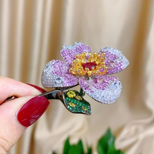Close-up of a luxury floral brooch with gradient pink petals and sparkling crystals