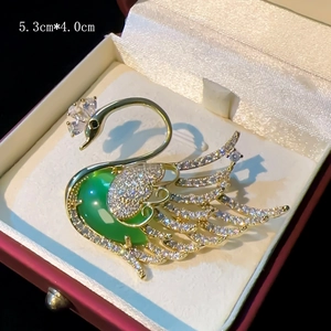 Elegant gold swan brooch with green gemstone and sparkling zircons, 5.3cm x 4.0cm
