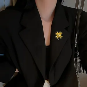 Detailed close-up of a golden four-leaf clover brooch with a number 5 on a black suit lapel