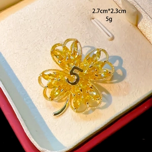 Detailed view of four-leaf brooch with yellow zircon petals and number 5 center