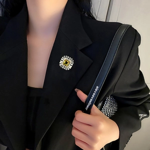 Elegant emerald-cut yellow zircon brooch with silver base on black suit jacket