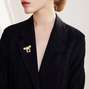 Broche nœud avec pierre précieuse jaune sur revers noir pour un style de luxe élégant