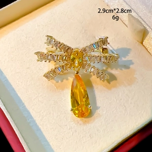 Vue macro d'une broche nœud dorée avec pierre jaune en forme de goutte d'eau