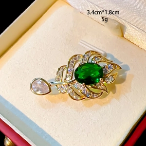 Macro detail of leaf brooch with green stone and pavé zircons, size 3.4cm by 1.8cm