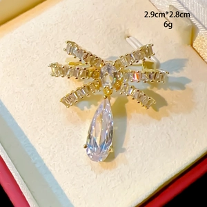 Vue détaillée d'une broche nœud avec incrustation de zircon et pendentif goutte d'eau