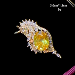 Vue macro d'une broche en cristal avec gemme jaune et zircons blancs 3x1,5cm