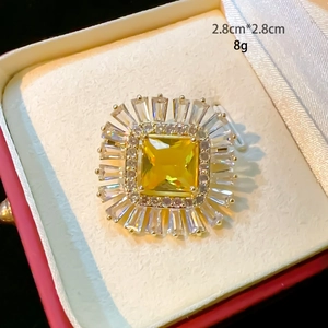 Detail of square emerald-cut yellow zircon brooch with sunburst diamond halo decor