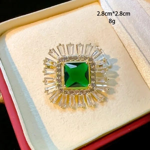 Macro shot of 2.8cm emerald green zircon brooch with square halo and gold finish