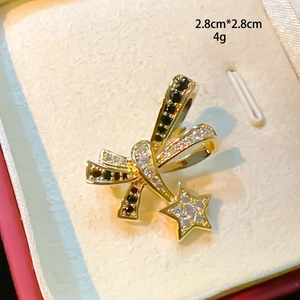 Detail view of a 2.8cm bow brooch with star pendant and inlaid sparkling zircon stones