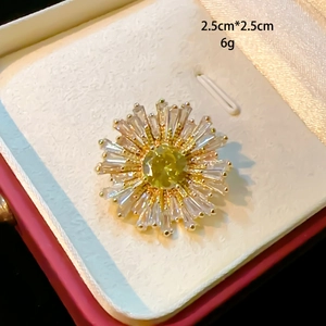 Macro shot of 2.5cm sunflower brooch with yellow zircon and gold finish in a gift box
