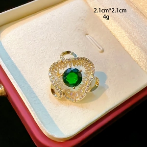 Macro detail of a 2.1cm heart brooch with emerald green stone and zircon inlay
