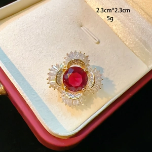 Macro shot of 2.3cm floral brooch with a large red crystal and white zircon accents