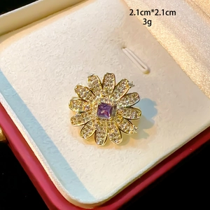 Detailed macro view of 2.1cm flower brooch with purple gemstone and cubic zirconia