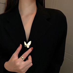 Elegant butterfly shell brooch with hollow design and sparkling crystals on a black blazer