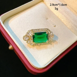 Close-up of a vintage emerald-cut green gemstone brooch in a luxury gift box