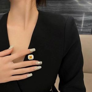 Eleganter quadratischer gelber Zirkon-Brosche mit Diamant-Halo auf schwarzem Blazer