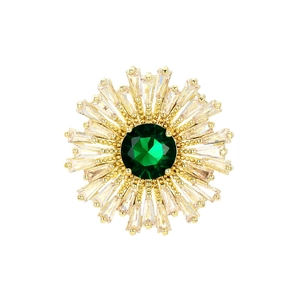 Elegant sunflower brooch with a green center stone and zircon crystals on a gold base