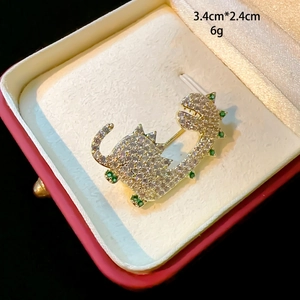Élégante broche dinosaure en or avec zircons blancs et détails en pierres vertes