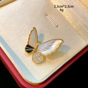 Detail view of a 2.3x2.3cm butterfly brooch with gold plating and shell inlay