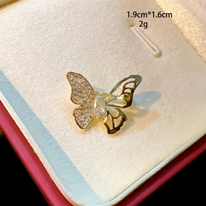 Close-up of golden butterfly brooch with sparkling crystals and hollowed wings