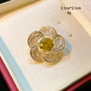 Detailaufnahme einer 2,1 cm Blumenbrosche mit gelbem Stein und Zirkon-Einlage in Gold