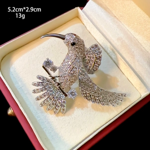 Detailed view of silver hummingbird brooch with white cubic zirconia, 5.2cm x 2.9cm size