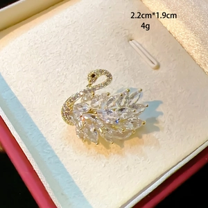 Macro shot of a mini gold swan brooch with crystals, size 2.2cm by 1.9cm and 4g weight