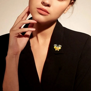 Close-up of elegant butterfly brooch with yellow crystals worn on a black blazer