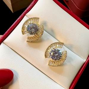 Close-up of gold-plated evil eye earrings with sparkling cubic zirconia in a red box