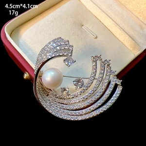 Macro view of crystal flower brooch with large pearl and zircon inlay in a gift box