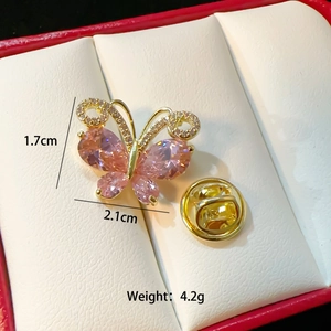 Macro shot of gold butterfly brooch with pink pear-cut gemstones and tiny zircons