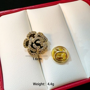 Detail of rose-shaped rhinestone brooch with pavé zircon petals and gold backing