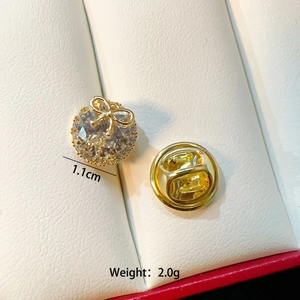 Macro detail of 1.1cm butterfly bow brooch with large sparkling crystal and gold plating