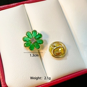 Macro shot of 1.3cm gold floral pin with green crystals and a butterfly clutch back