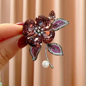 Detail of purple crystal flower brooch with shimmering stones and freshwater pearl