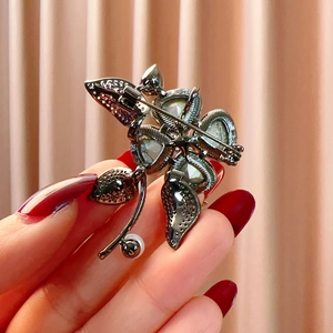 Detail view of flower brooch back with textured metal and secure pin clasp mechanism