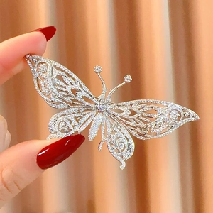 Broche papillon argentée exquise avec ailes ajourées et zircons scintillants sertis