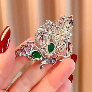 Detail view of the silver butterfly brooch back showing secure pin and hollow metal base