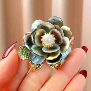 Détail de la broche pivoine avec nacre noire, perle blanche et feuilles de zircon vert
