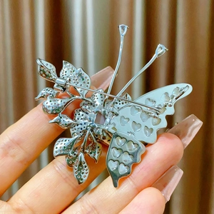Detailed back view of a butterfly brooch showing heart cutouts and a safety pin clasp