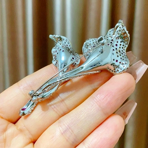 Detailed back view of silver calla lily brooch with safety clasp and hollow metal structure