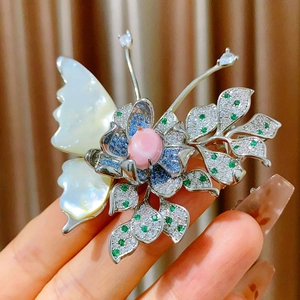 Elegant butterfly brooch with white shell wing and colorful crystals in gold setting